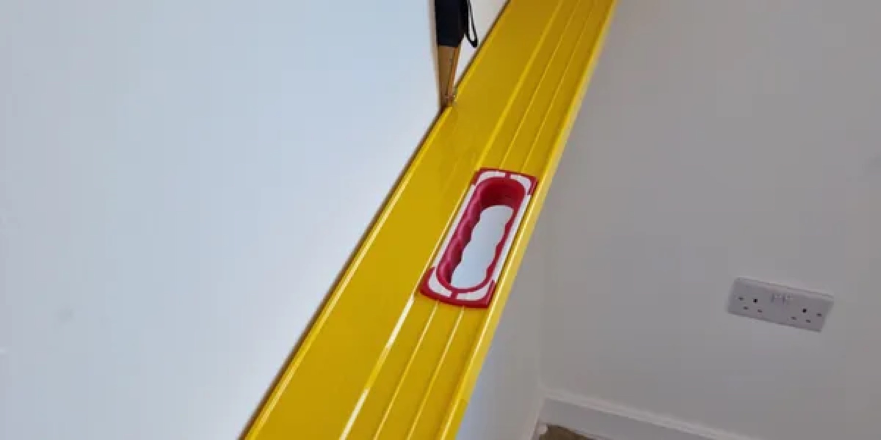 A spirit level held against a wall during an inspection